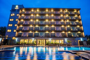 A multi-story hotel with a swimming pool in the foreground. - Savotel (Sattahip)
