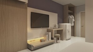A modern hotel room with a flat-screen TV mounted on the wall, a small seating area with a stool, a refrigerator, and a side table with a lamp and a book. - Silom Boutique Hotel Hatyai (Hat Yai)
