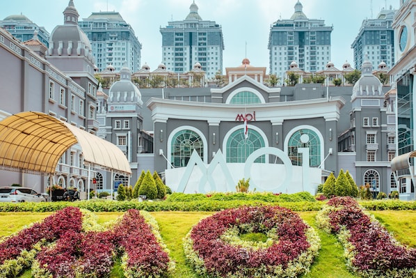 A hotel with a large central building featuring arched windows and a prominent 'MOT' sign.