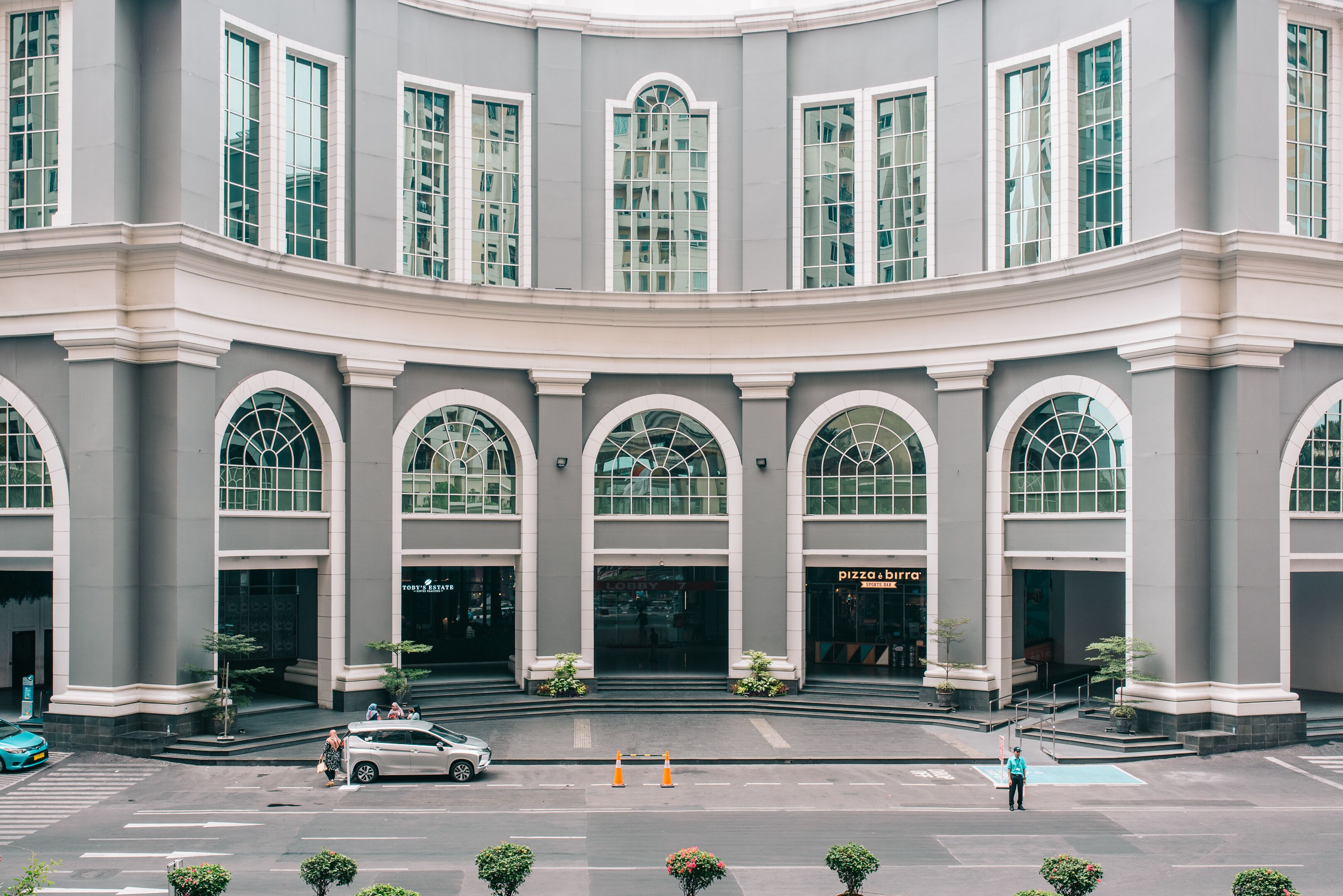 Un grand bâtiment doté de nombreuses fenêtres en arc de cercle et d’une entrée centrale.