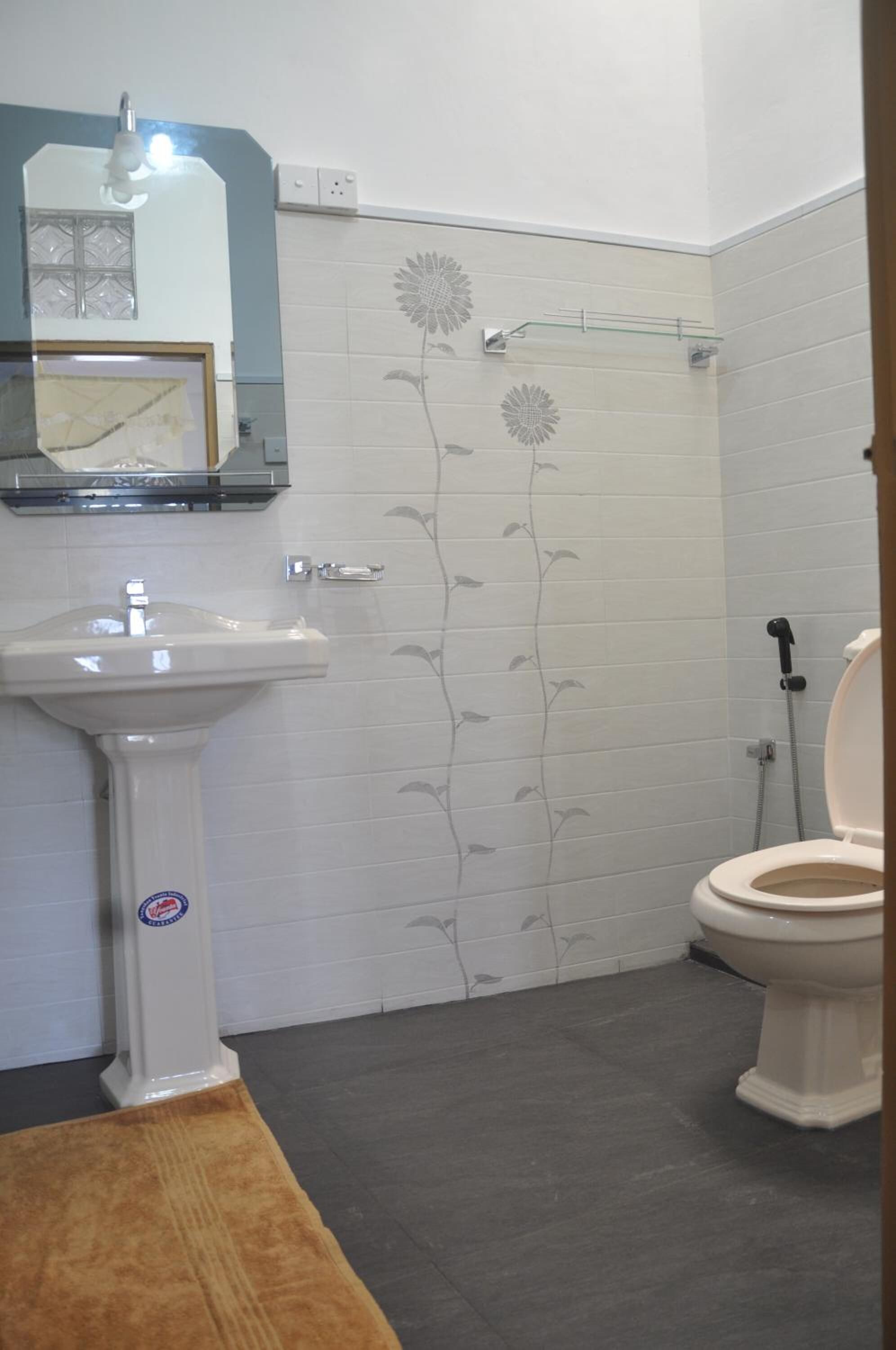 A bathroom with a white sink, a toilet, and a shower.