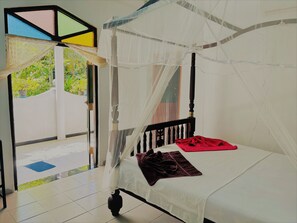 Une chambre avec un lit, une fenêtre et une vue sur la verdure.