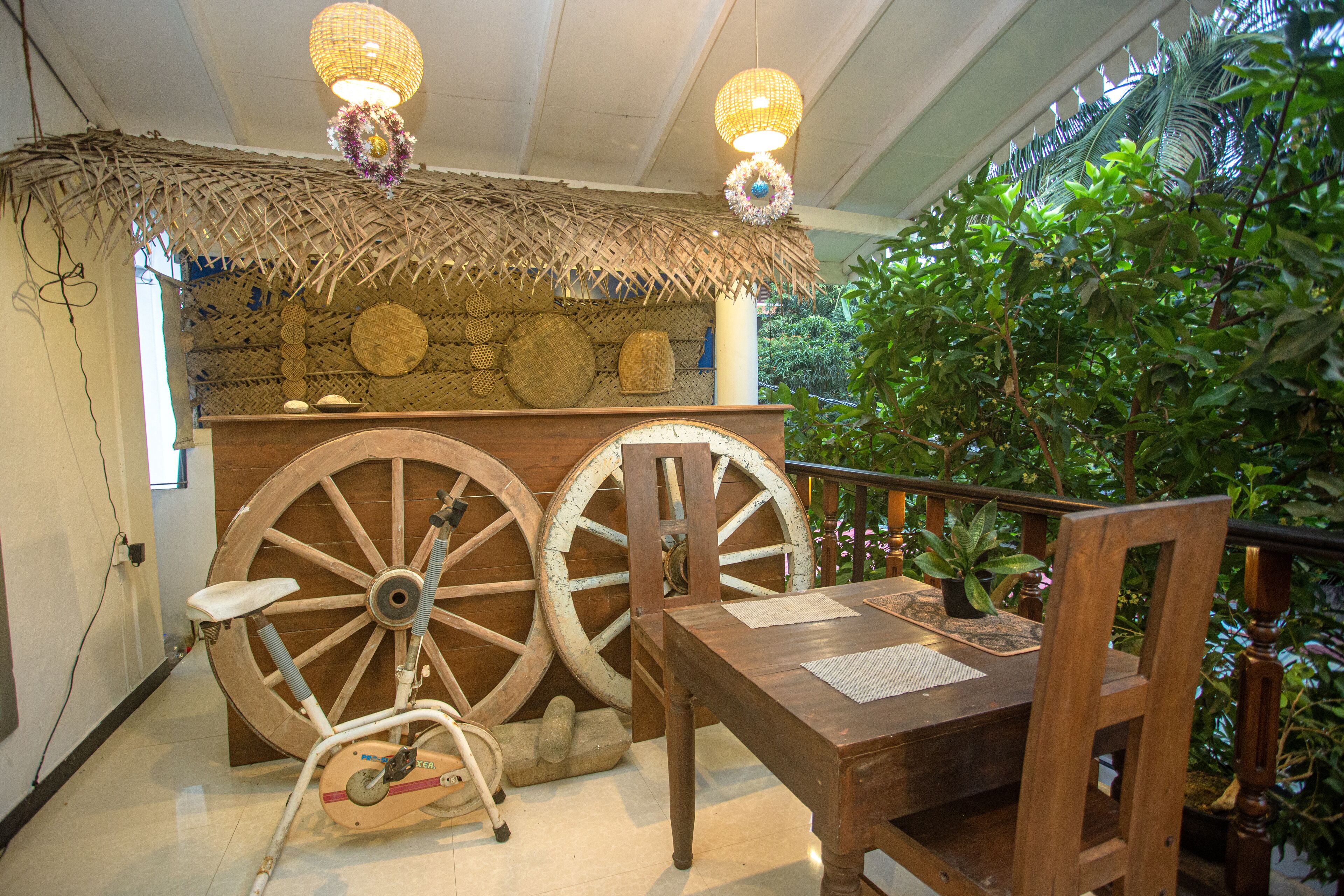 Un intérieur rustique avec une table en bois, des chaises et une structure de toit en chaume.