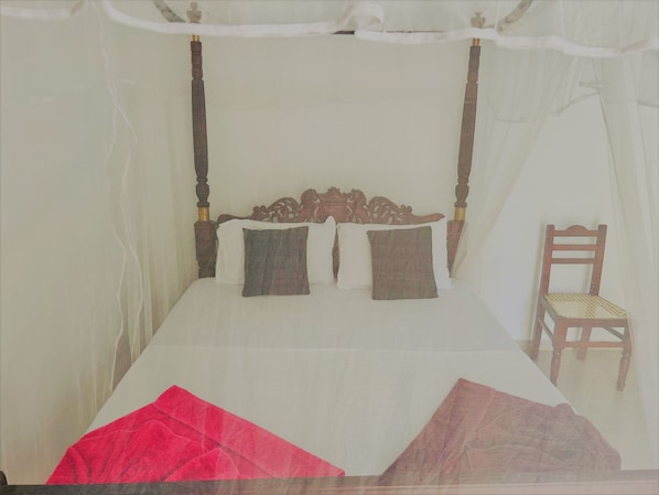 A bed with a canopy, a wooden headboard, and two pillows.