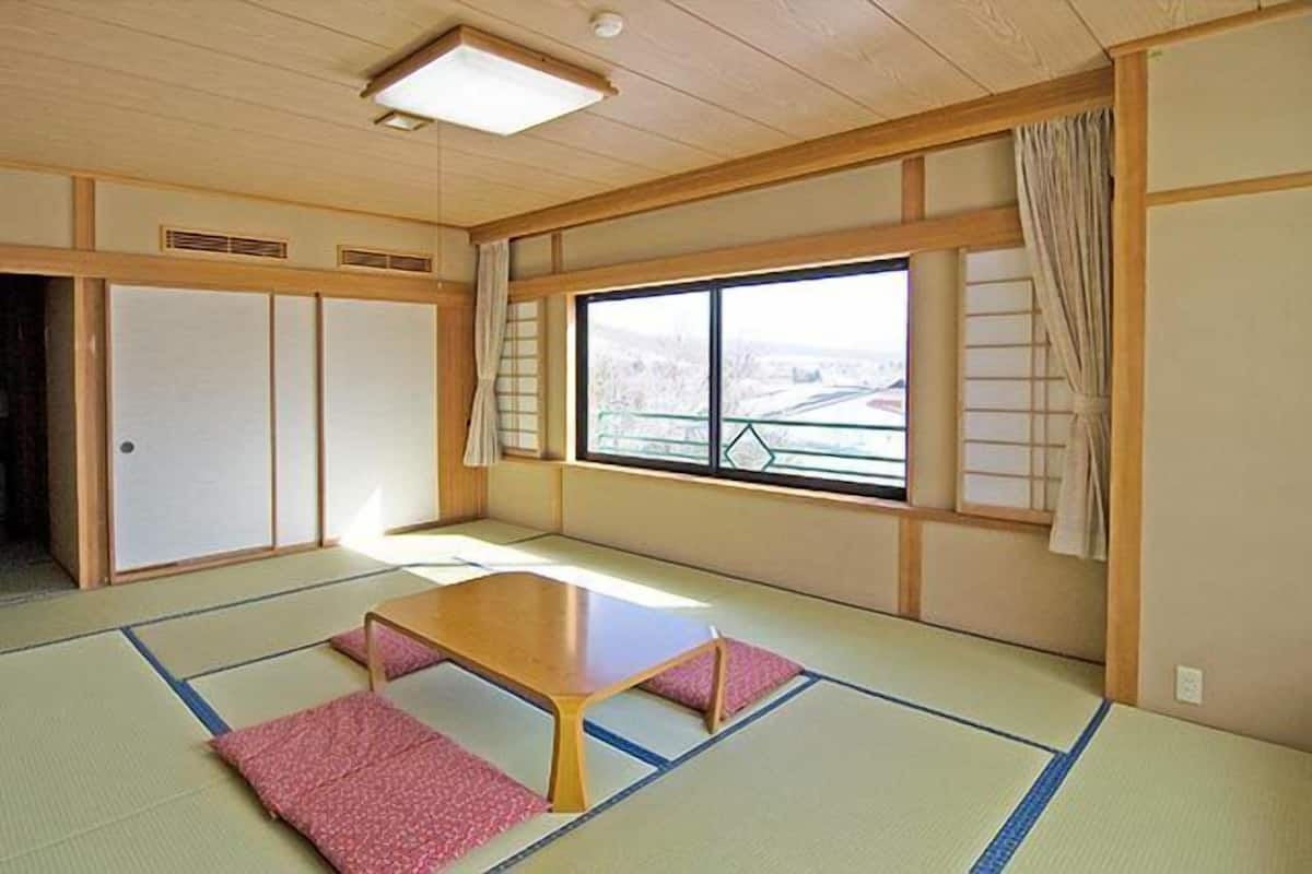 A traditional Japanese room with tatami flooring, a low wooden table, and sliding doors.