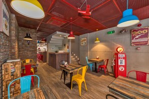 A restaurant interior with brick walls, wooden tables, colorful chairs, and red ceiling accents. - Taksim Nis Hotel (Istanbul)