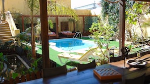 A pool area with a small pool, lounge chairs, and a table with a chess set. - Casa Mestre Guesthouse (Vila do Bispo)