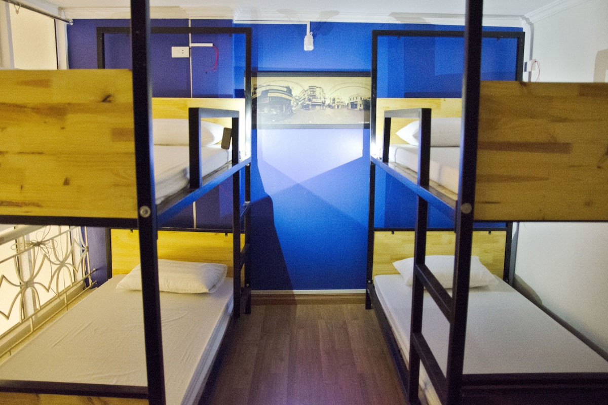 A bunk bed room with a blue wall and a poster.