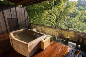 A hot tub on a wooden deck with a glass railing overlooking a forested area. - wa-tei Kazekomichi (Atami)