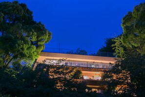 A modern building with a glass facade, surrounded by trees. - wa-tei Kazekomichi (Atami)