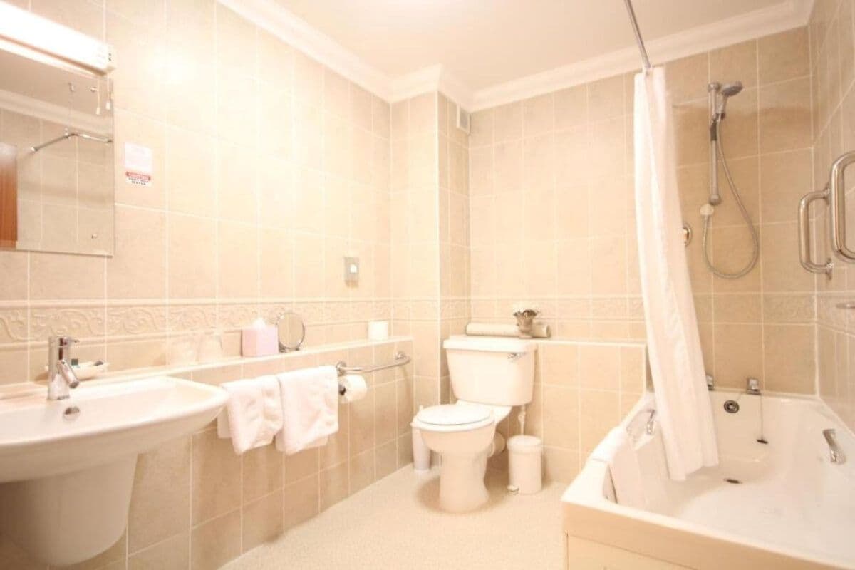 Une salle de bain équipée d’un lavabo, de toilettes, d’une baignoire et d’une douche.