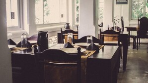 A dining area with wooden tables and chairs, a pitcher, and a sign requesting silence. - Plantation Villa Ayurveda Yoga Resort (Dodangoda)