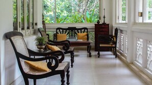 A traditional room with a wooden bench, a table, and a potted plant. - Plantation Villa Ayurveda Yoga Resort (Dodangoda)