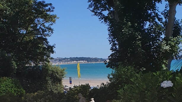 A table with food and a view of the beach. - La Haule Manor (St. Brelade)