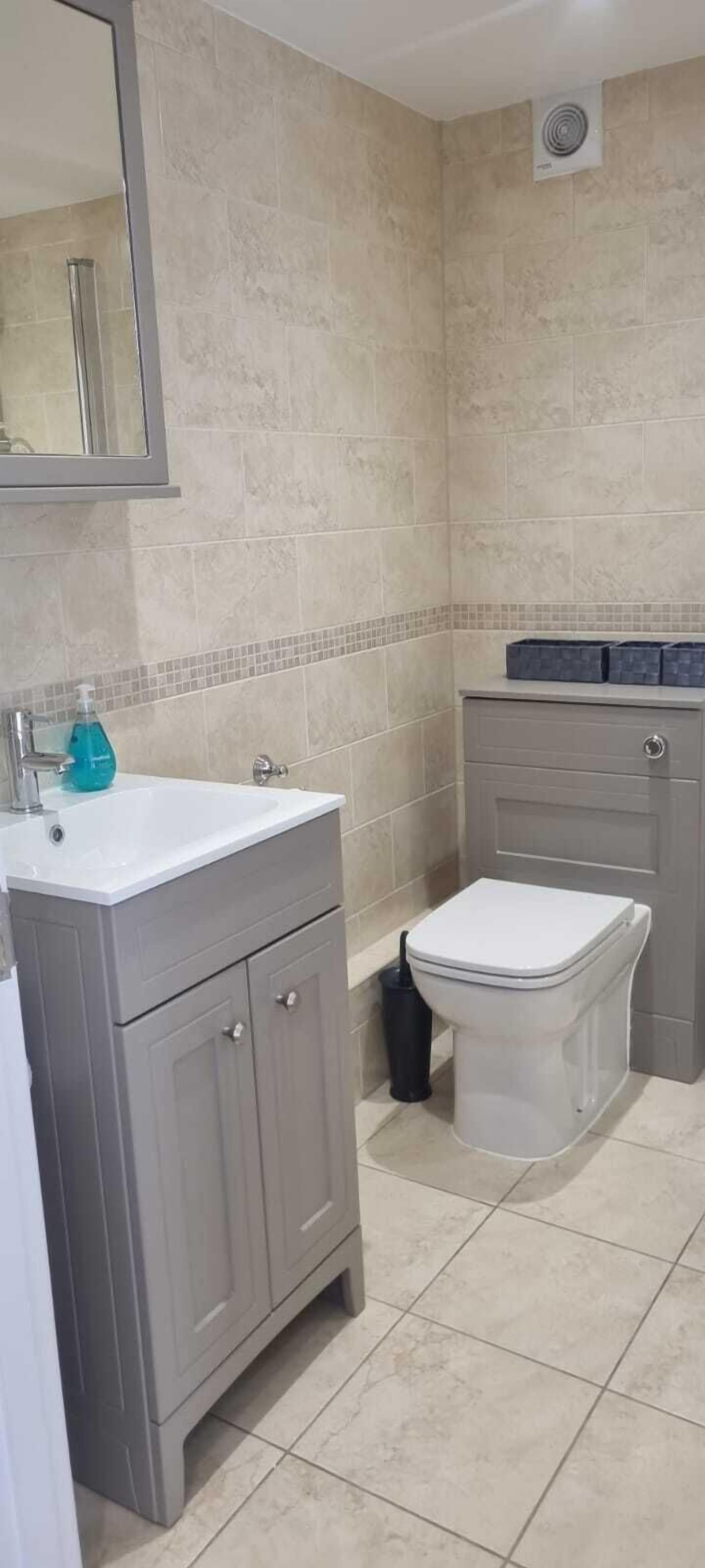 A bathroom with a white sink, a toilet, and a mirror.
