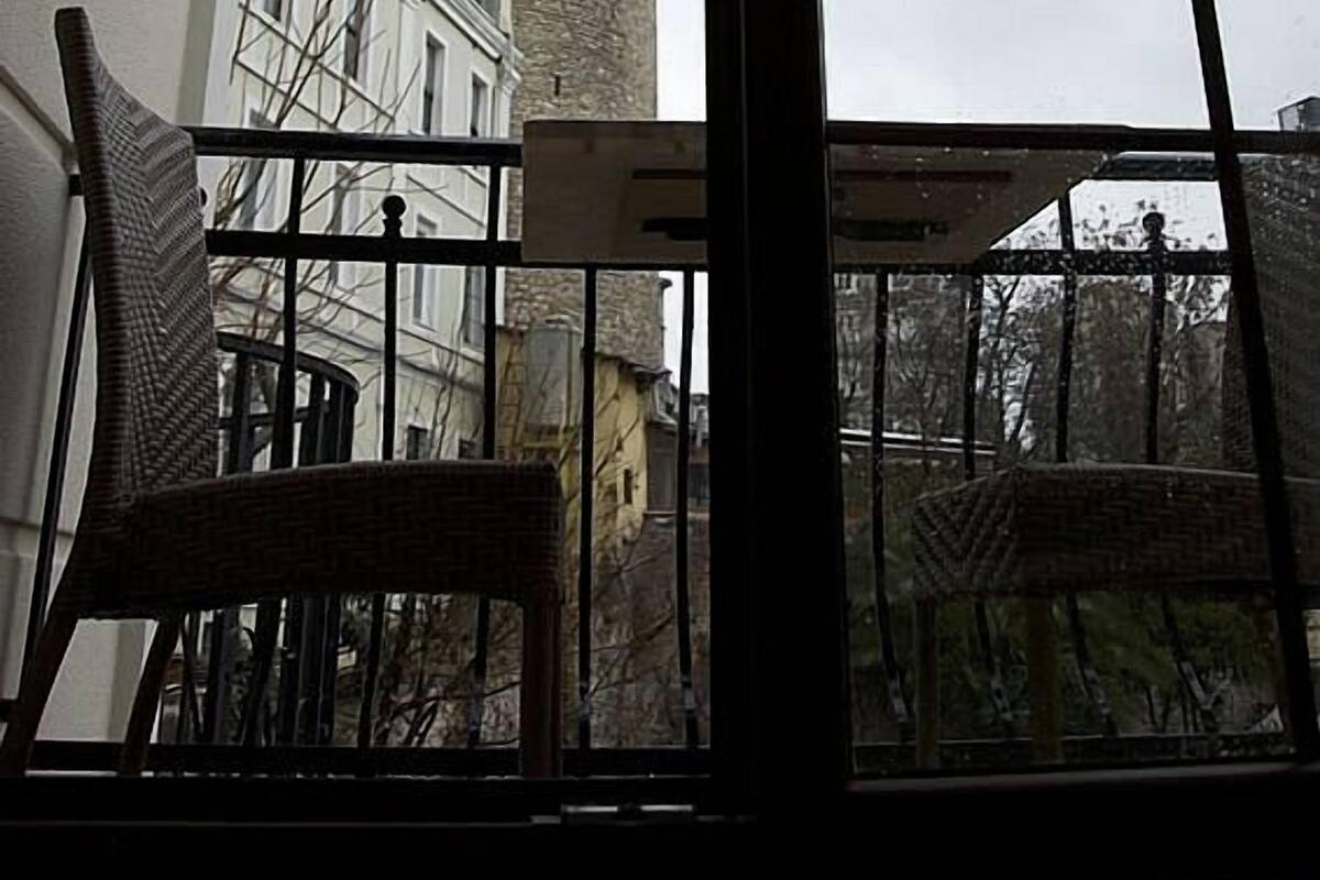 A room with a view of a historic tower through a window.