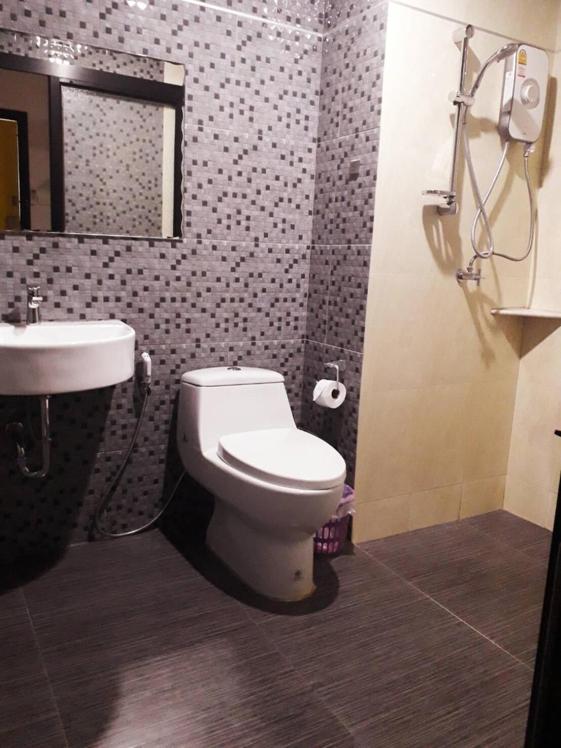 A bathroom with a toilet, sink, and shower.