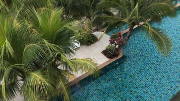 Una piscina en la azotea rodeada de palmeras.