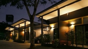 A modern building with a covered outdoor area, large windows, and a tree in the foreground. - Rimnatee Resort Trang (Trang)
