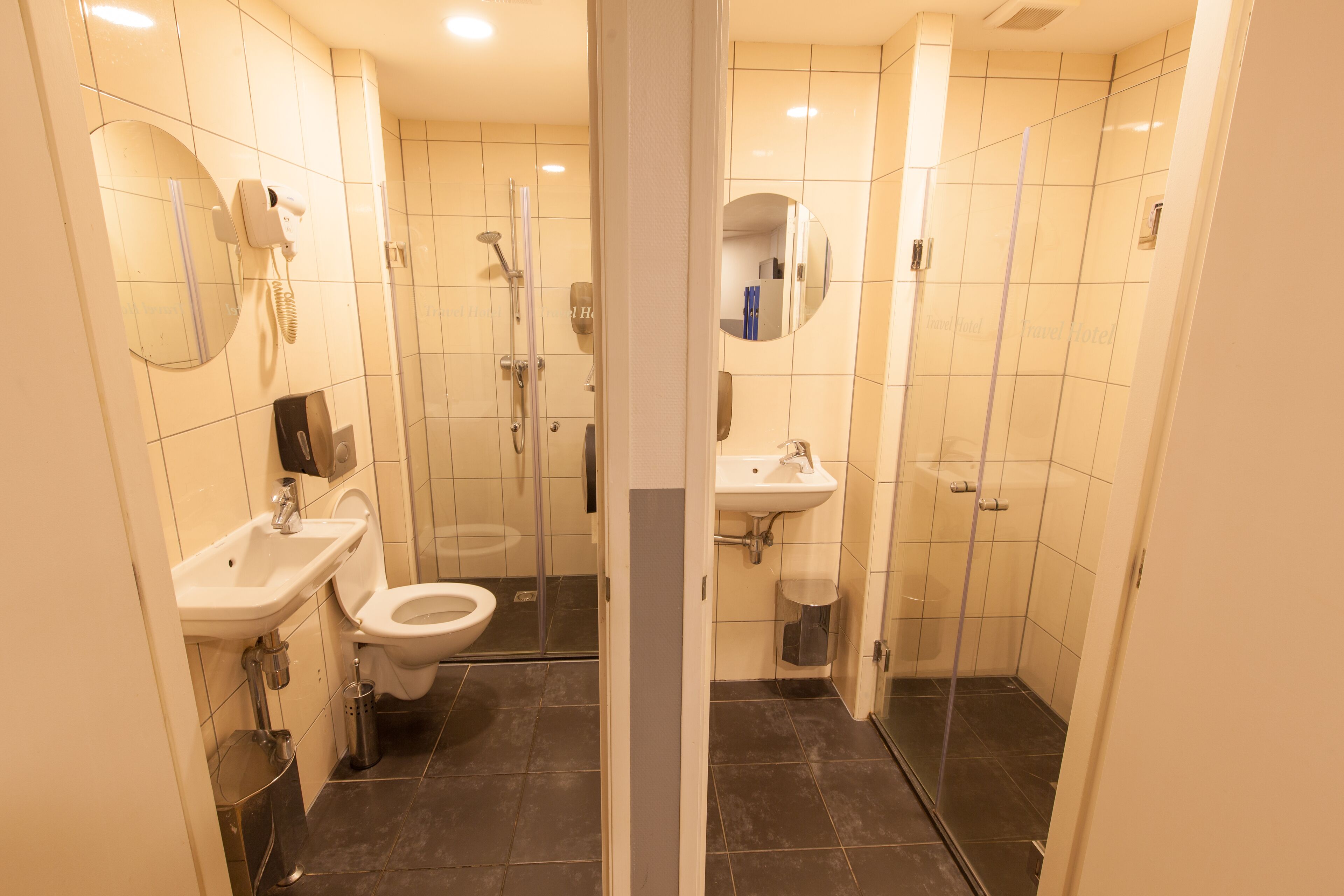 Une salle de bain moderne équipée de toilettes, d’un lavabo et d’une zone douche.