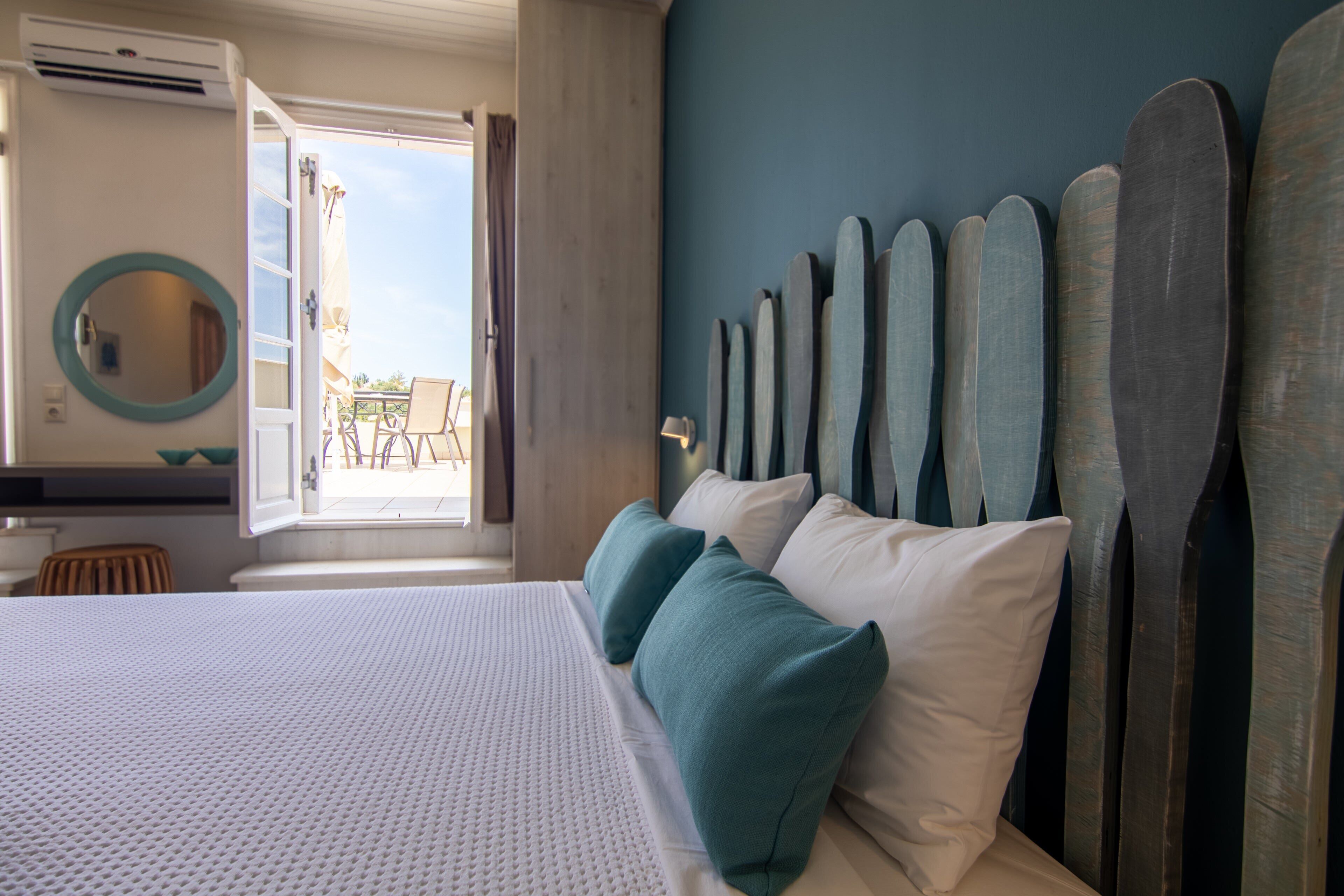 Habitación de hotel con cama, un espejo grande y vistas al exterior.