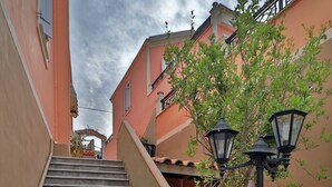 A staircase leading up to a building with a beige and pink facade. - Fiscardo Studios (Kefalonia)