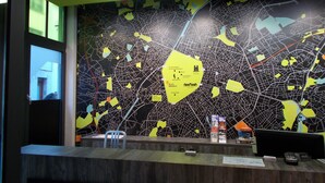 A reception desk with a map of the city, a chair, and a counter. - Urban City Centre Hostel (Brussels)