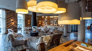 A spacious lobby with a modern design, featuring a large seating area, a coffee table, and a fireplace. - Urban Lodge Hotel (Amsterdam)