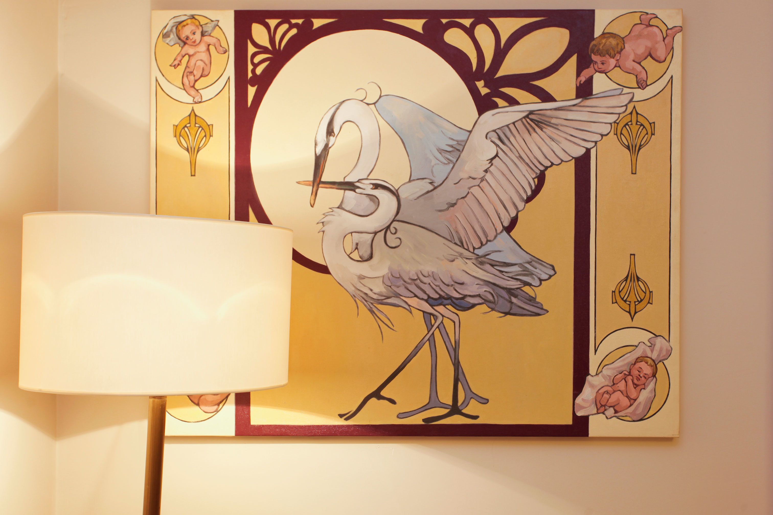 Una pared con un cuadro enmarcado de un pájaro y querubines.