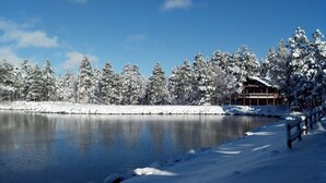 A snow-covered landscape with a wooden cabin by a lake. - Lake of the Woods Resort (Lakeside)
