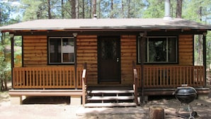 A cabin with a front porch, a chimney, and a grill outside. - Lazy Oaks Resort (Lakeside)