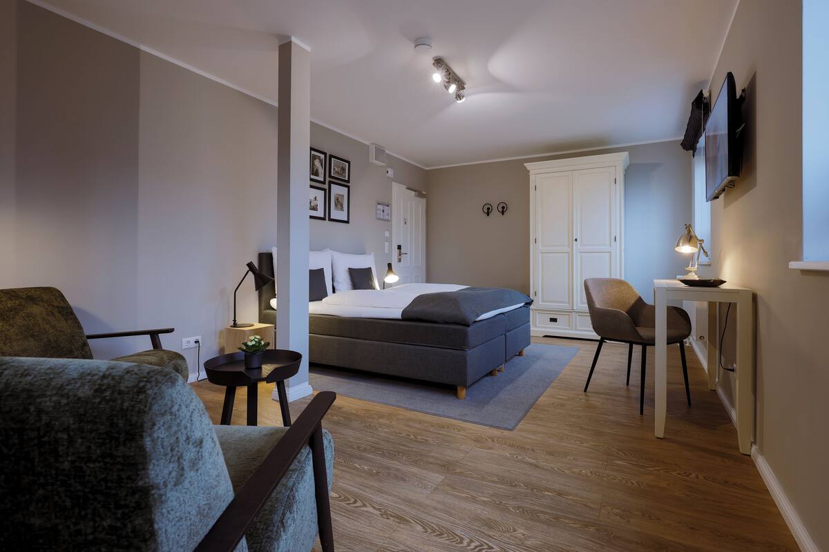 A modern bedroom with a bed, a desk, and a chair.