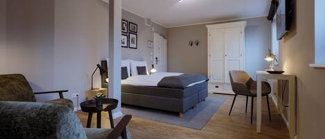 A modern bedroom with a bed, a desk, and a chair.