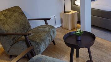 A modern living room with a sofa, a coffee table, and a side table with a lamp.