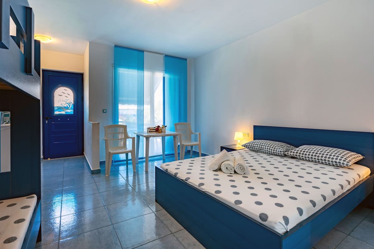A hotel room with a bed, a desk, and a chair.
