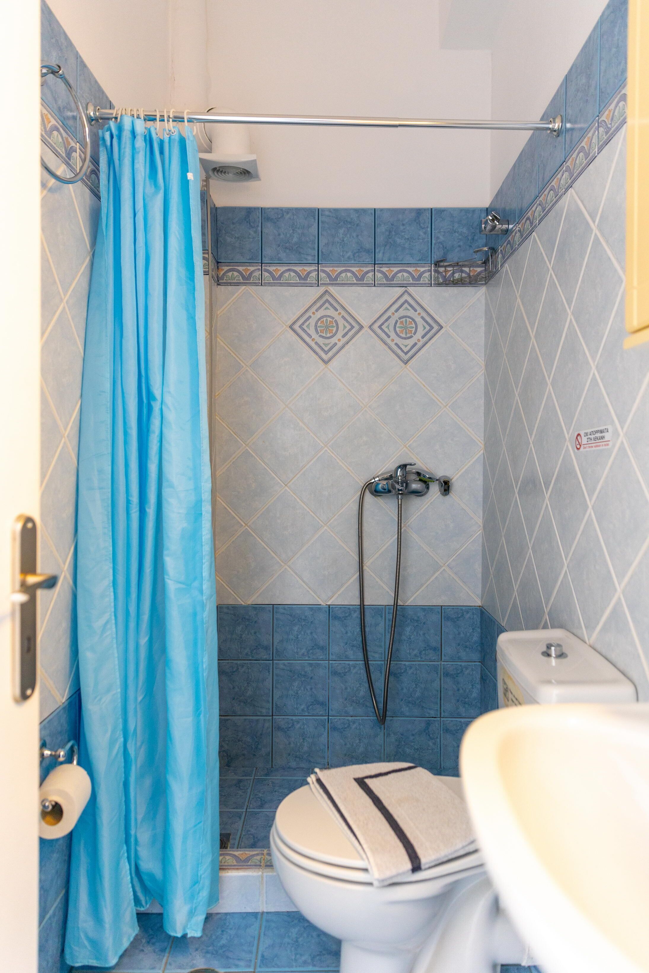 Un bagno con doccia, WC e lavandino.