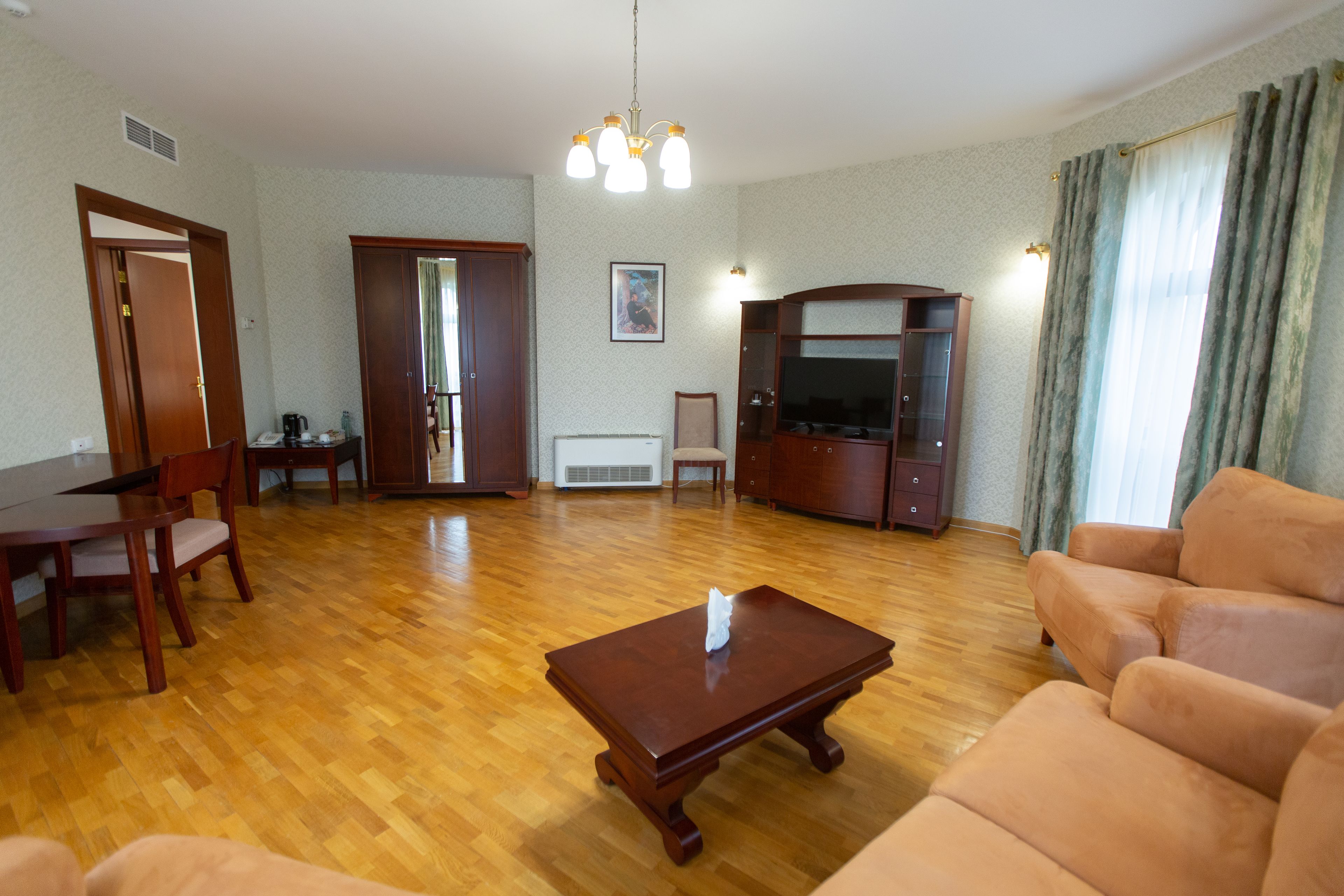 Una sala de estar con una mesa de centro de madera, un sofá color beige y un televisor.