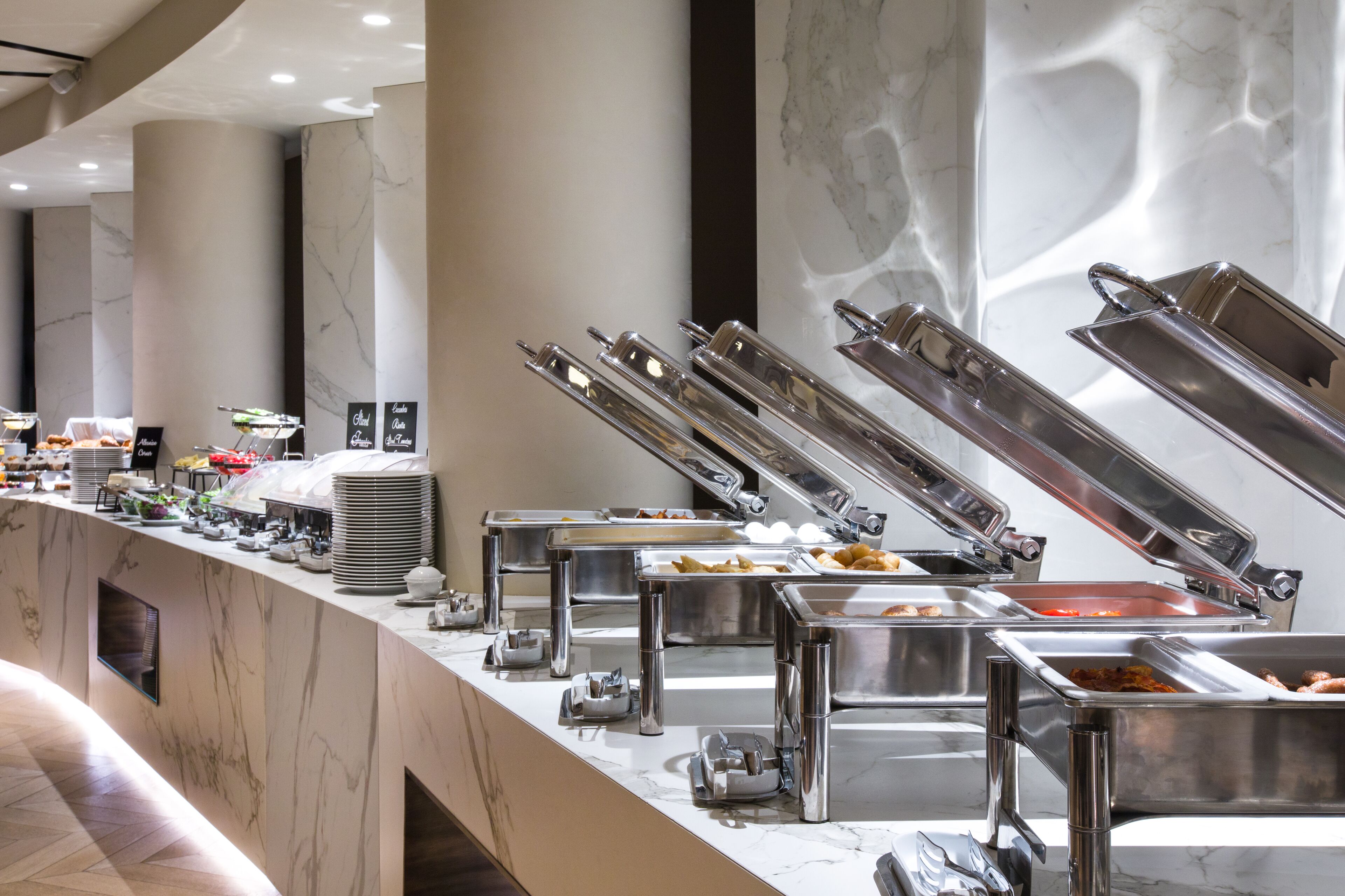 Un buffet avec plusieurs présentoirs de nourriture et des ustensiles de service.