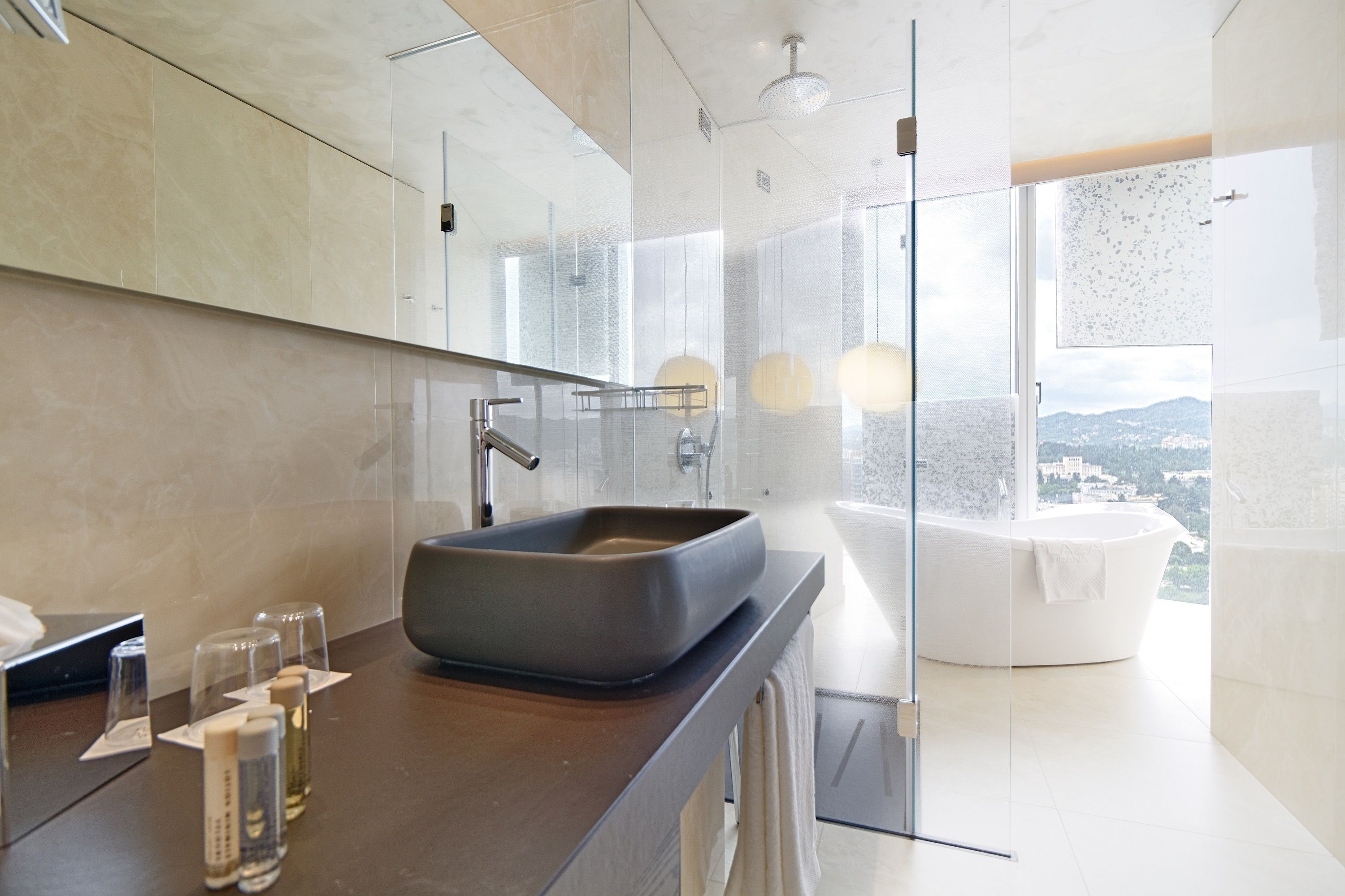 A modern bathroom with a large mirror, a rectangular sink, and a bathtub.