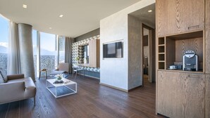 A modern living room with a sofa, coffee table, and a TV mounted on the wall.