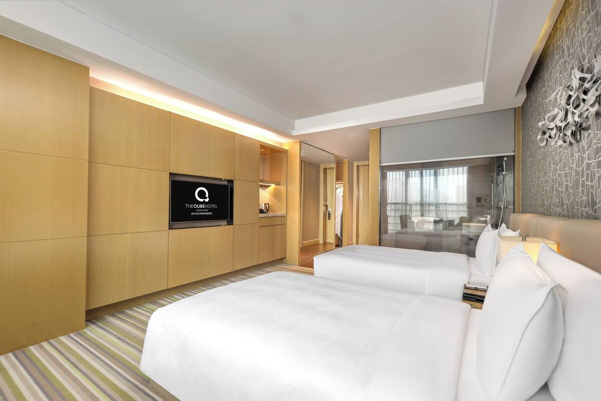 Une chambre d’hôtel avec un grand lit, une télévision et un miroir.