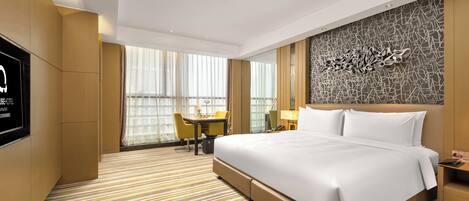 Habitación de hotel con una cama grande, un escritorio, una silla y un televisor.