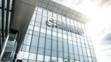 A modern building with a glass facade and a prominent logo.