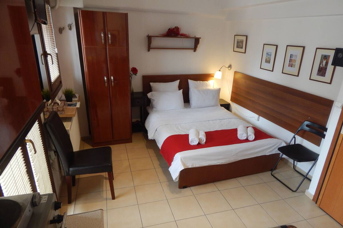 Ein Hotelzimmer mit einem Bett, einem Holzschrank, einem Schreibtisch und einem Stuhl.