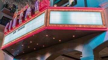 Un cartel de cine exhibe la frase 'Now Showing', indicando que se trata de un cine dentro de un hotel.