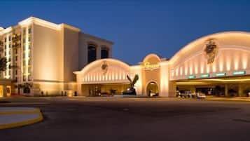 Un hotel con una entrada imponente, varios pisos y una fachada bien iluminada.