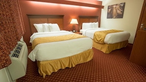 Una habitación de hotel con dos camas, una lámpara y un cuadro en la pared.