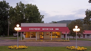 Un edificio con toldo rojo identificado como 'Shepherd Mountain Inn'.
