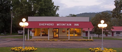 Un edificio con toldo rojo identificado como 'Shepherd Mountain Inn'.