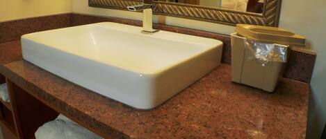 A bathroom with a white sink, a mirror, and a towel rack.
